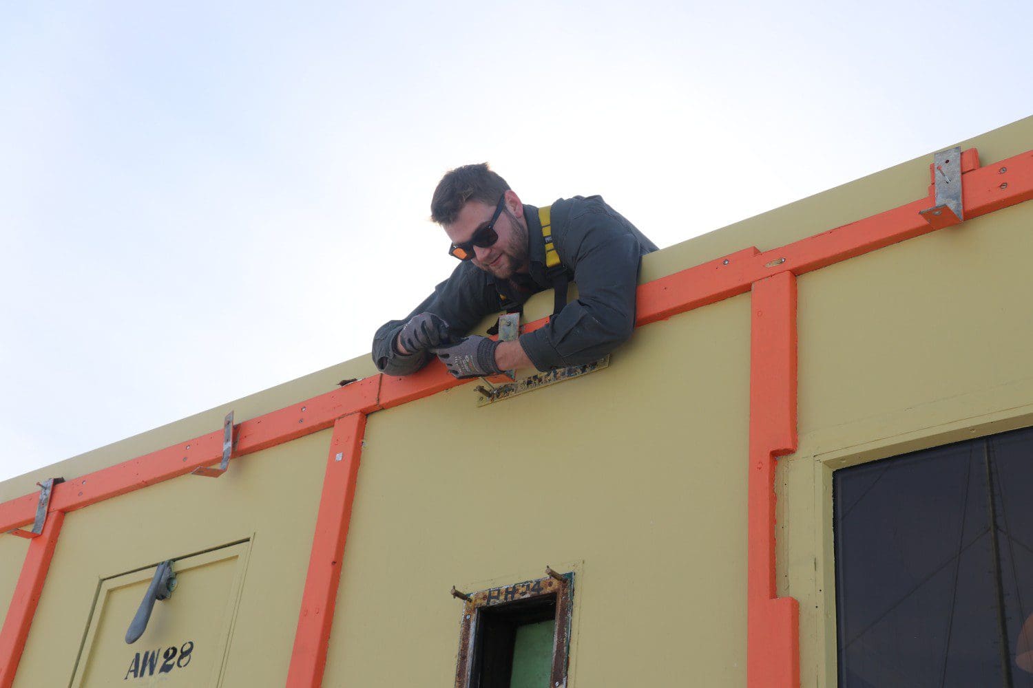 Antarctic Youth Ambassador Chris Ansin working on the hut roof