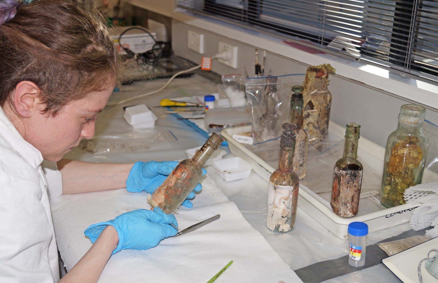 Josefin conserves the deteriorated labels on bottles of pickel and L&P's worcestershire sauce