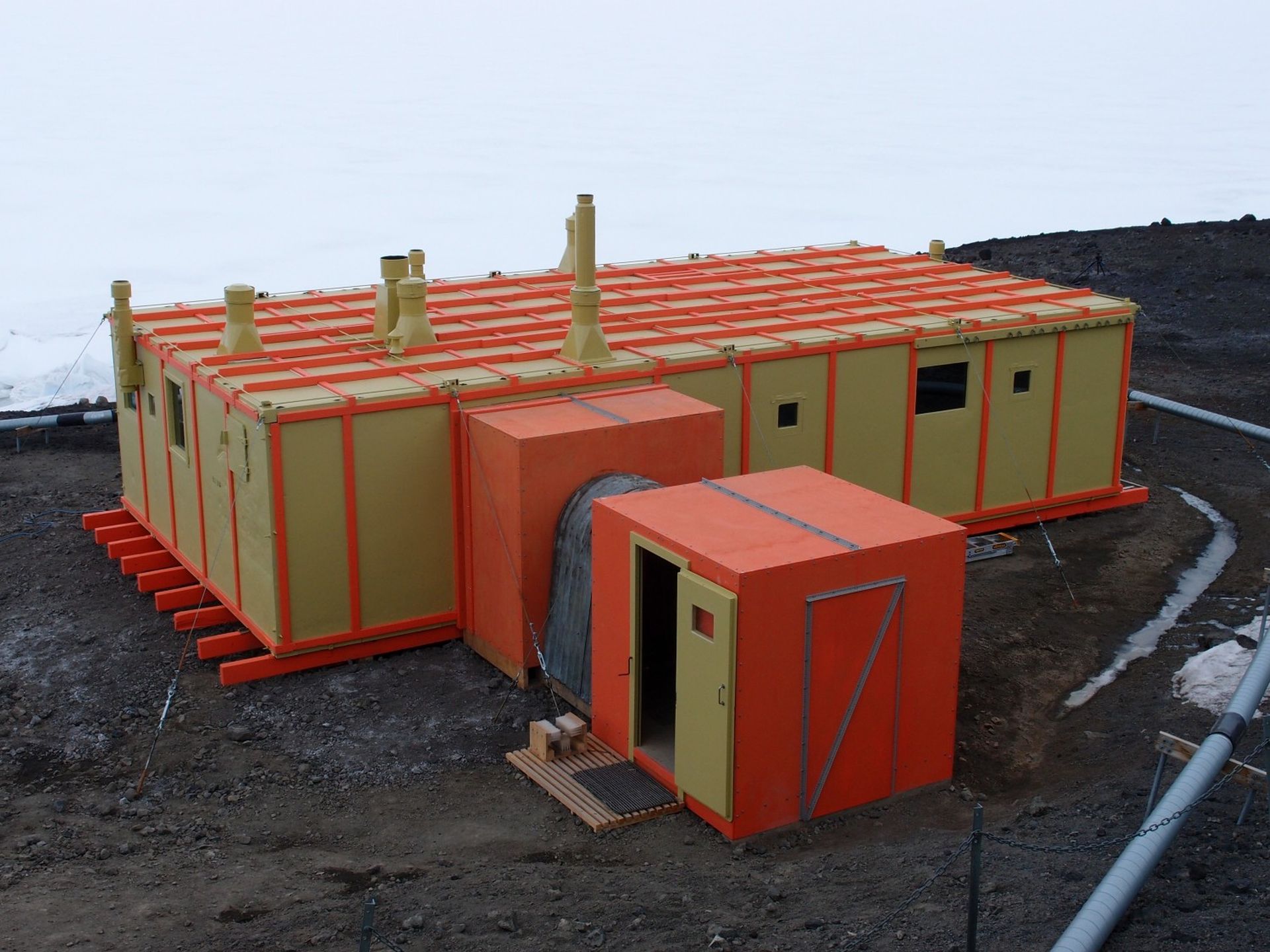Hillary's Hut featuring its original colours, renamed by the Trust as 'Pram Point (yellow) and 'Sno-cat' (orange).