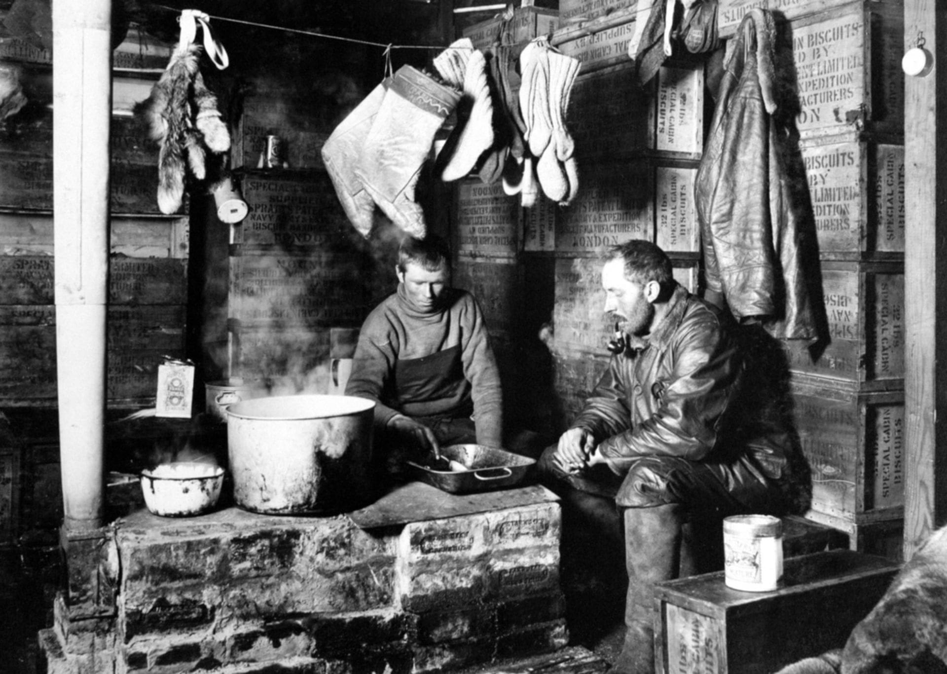 Dimitri and Meares (members of Scott's 1910-13 Expedition) around the blubber stove at Hut Point, 3 November 1911