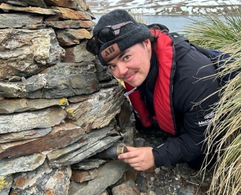 Inspiring Explorer Charlie Thomas replacing the ‘Quest’ expedition photo inside the Hope Point cairn. Antarctic Heritage Trust Grytviken Inspiring Explorers Expedition