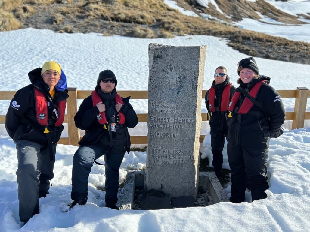Inspiring Explorers Porohu Hagai Noa, Destiny Martin, Lawrence Rothwell and Kaitlyn Martin at Shackleton's grave in Grytviken cemetery. Antarctic Heritage Trust Grytviken Inspiring Explorers Expedition