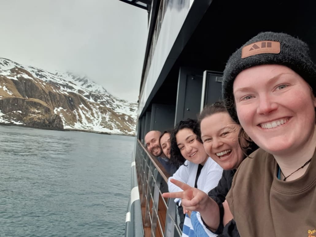 People smiling at the camera while on a boat