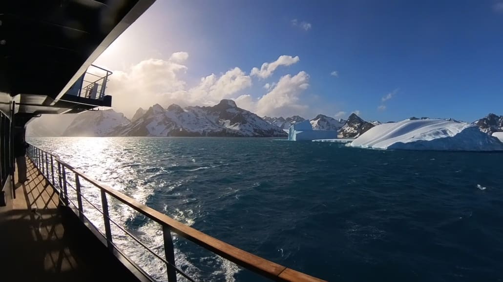 Icebergs and snowy mountains seen from a boat.