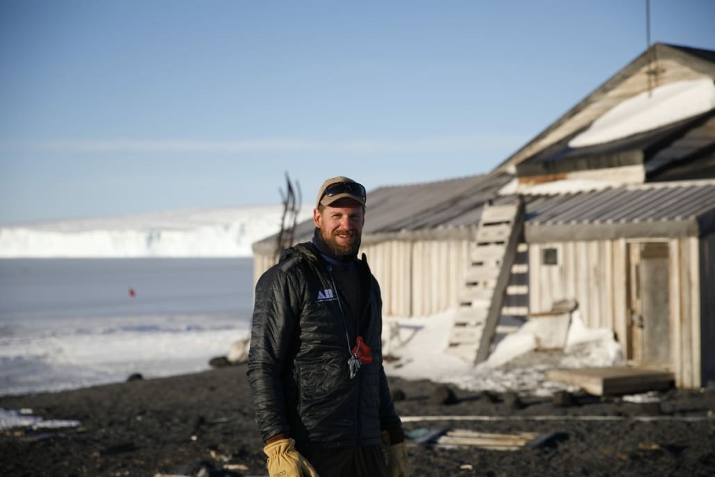 A man standing in front of a historic building in Antarctica