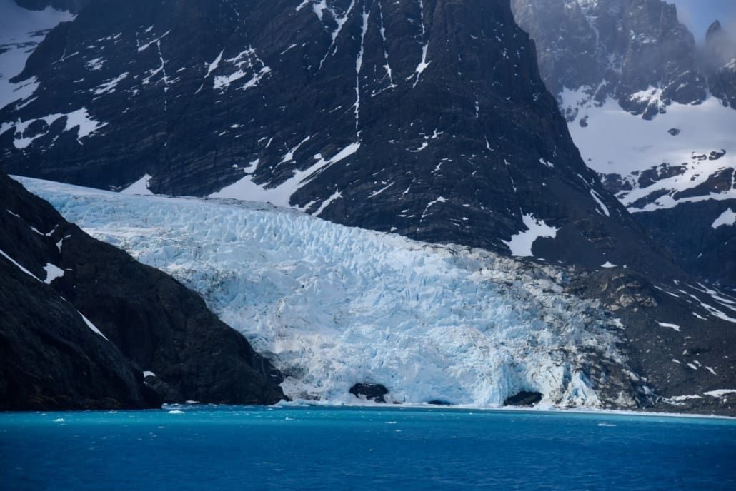 A large glacier surrounded by rocky mountain faces.